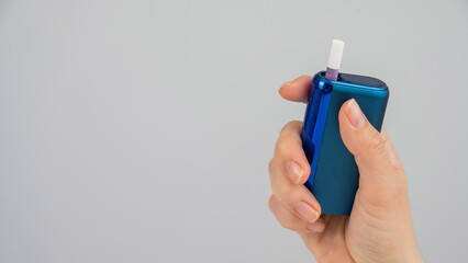Woman holding electronic cigarette on white background. Tobacco heating systems.