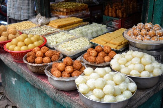 An assortment of tasty Bengali sweets including gulab jamun rasogulla kaju barfi kheer kadam sandesh and laddu showcased at a street food stall in Kolkata