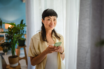 japanese woman use mobile phone app at home, leisure activities