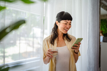 japanese mature woman drink water and use mobile phone at home
