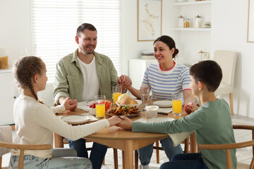 Family praying together before dinner at table indoors