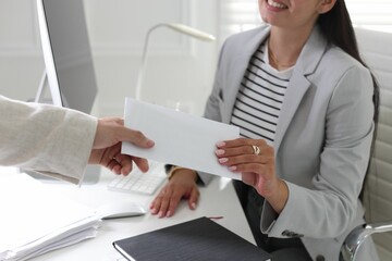 Obraz premium Money bonus. Employee receiving envelope from boss in office, closeup