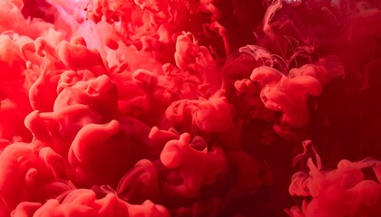 A macro shot reveals vibrant red dye dispersing in liquid, creating a mesmerizing cloud-like effect.