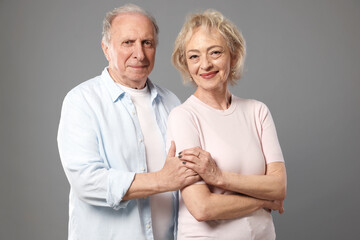 Portrait of lovely senior couple on grey background