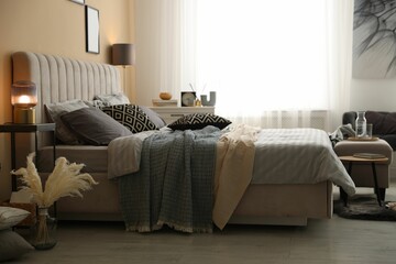 Comfortable bed with soft linens and blankets in room. Home textile