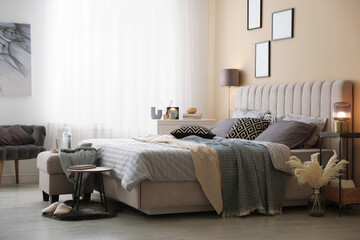 Comfortable bed with soft linens and blankets in room. Home textile