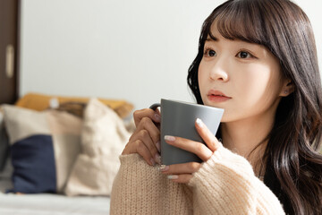 コーヒー・紅茶を飲む若い女性　クローズアップ
