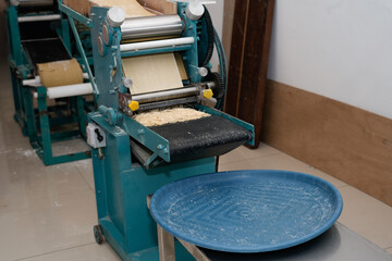 freshly extruded thin yellow noodles for making wonton noodles