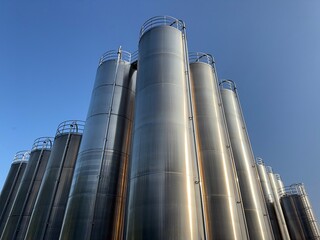 Large stack of metal tanks with a blue sky in the background