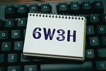 There is notebook with the word 6w3h. It is an abbreviation for When, Where, Who, What, Why, How,...