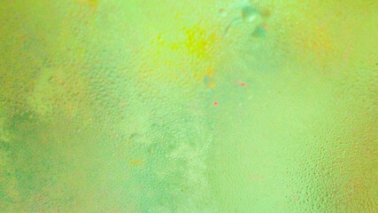 Abstract background of water drops on glass with yellow gradient light