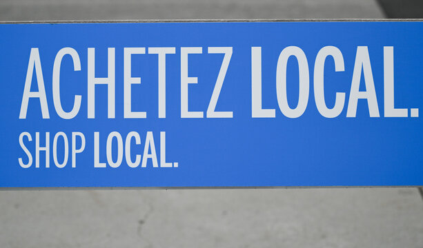 A shop local sign in French and English