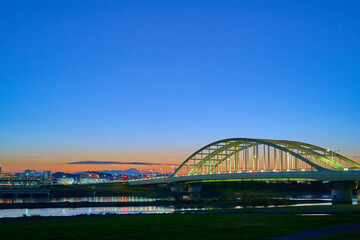 Obraz premium 日没後の東京都狛江市の多摩川河川敷から西側の眺望(多摩川,多摩水道橋交差点,富士山,ブルーアワー)