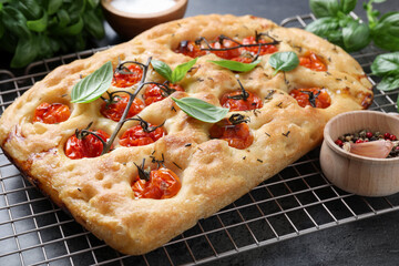 Delicious focaccia with tomatoes and spices on table, closeup