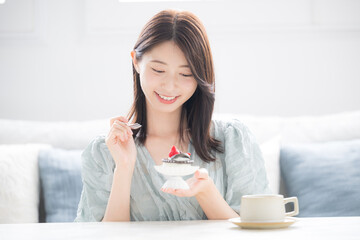 甘いスイーツを笑顔で食べる女性　スイーツは別腹