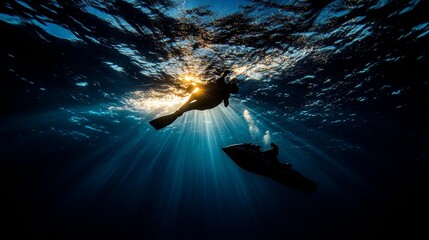 Underwater silhouettes of a diver and jet ski, sunbeams illuminating the scene