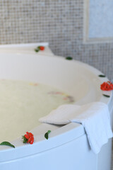Relaxing hotel jacuzzi with foam and scattered roses, creating a luxurious and romantic atmosphere