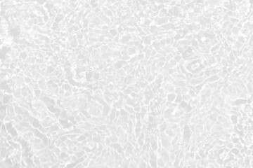 White water with ripples on the surface. Defocus blurred transparent white colored clear calm water surface texture with splashes and bubbles. Water waves with shining pattern texture background.