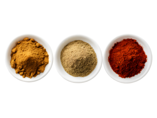 A top view of three small white bowls filled with different colored spices on a black background