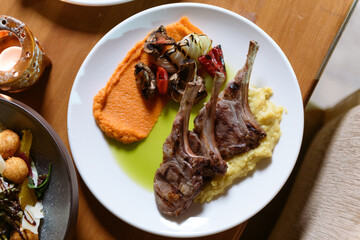 Succulent grilled lamb served on creamy mashed potatoes with charred seasonal vegetables for an elegant hotel dining experience
