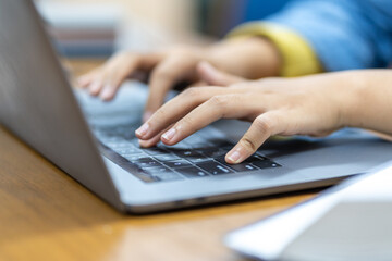 Close-up of a person typing on a laptop keyboard