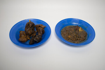 The blue plate contains chicken livers, and a savory dipping sauce.