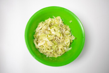 Light and crunchy cabbage salad ready to serve in a green bowl.