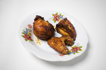 traditional fried chicken dish served on a floral patterned plate