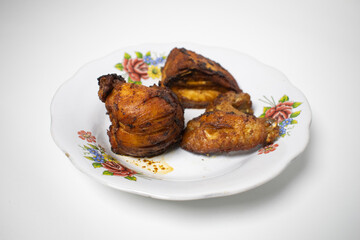 Fried chicken pieces are placed on a floral patterned plate, ready to be served as a delicious...