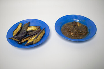 Fried eggplant served on a blue plate, combined with spicy chili sauce.