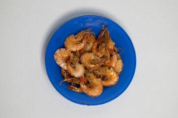 Whole fried shrimp, crunchy and savory, on a bold blue plate.