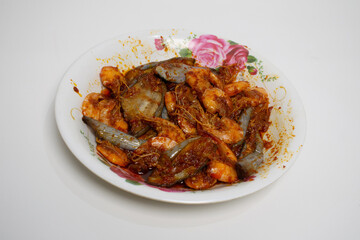 Spicy stir-fried shrimp and eggplant served on a floral plate, rich in red chili sauce.