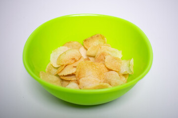 Crispy chips served in a bright green bowl on a white background.