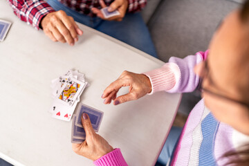 Senior couple playing cards at home, enjoying retirement together