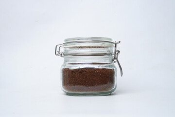 Glass jar filled with ground coffee isolated white background