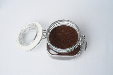 Glass jar filled with ground coffee isolated white background