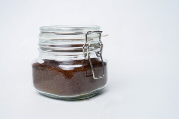 Glass jar filled with ground coffee isolated white background