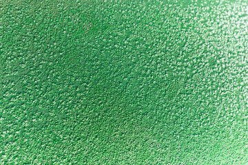 Fototapeta premium A layer of frost blankets the green exterior of a car on a crisp winter morning