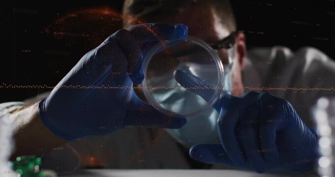 Lab researcher presenting petri dish tilting and probing sample under lab lighting for inspection
