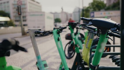 Close-up view of electric scooters parked on a city street in Portugal, highlighting urban mobility and sustainable transportation options. Row of Electric Scooters Parked in Urban Setting
