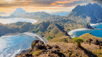 Grassy cliffs drop to ocean coast and mountain at Padar Island, Komodo National Park, Indonesia. Perfect summer holiday and tropical travel background.