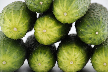 Visually appealing arrangement of fresh, green cucumbers, stacked to form a vibrant close-up image.