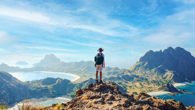 Man on hill with blue ocean and mountain panorama, Komodo Indonesia. Adventure, nature, and travel concept for summer vacation.