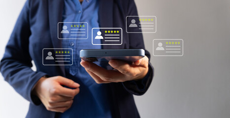 Close-up of a woman's hand holding a smartphone with a customer review and a star icon floating on...