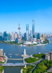 Aerial view of Shanghai skyline and winding river on sunny day.