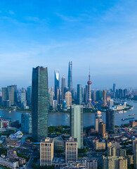 Aerial view of Shanghai skyline and winding river on sunny day.