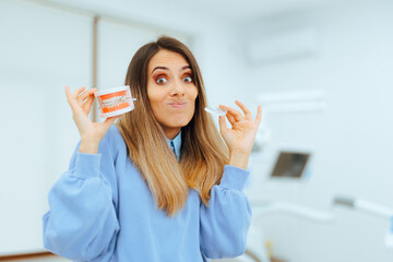 Undecided Patient Holds an Invisible and a Classic Braces. Woman tries to choose between teeth...