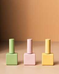Green, butter yellow and pink varnish bottles for female manicure, beauty salon glamour, gel nail design. Background for glamour beauty salon