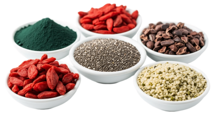 A variety of superfoods in white bowls including goji berries chia seeds and spirulina powder arranged closely