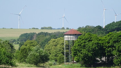 Old water tower and wind turbines in summer